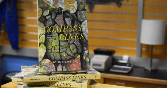 John Messick’s “Compass Lines” is displayed at the Kenai Peninsula College Bookstore in Soldotna, Alaska on Tuesday, March 28, 2023. The copy at the top of this stack is the same that reporter Jake Dye purchased and read for this review. (Jake Dye/Peninsula Clarion)