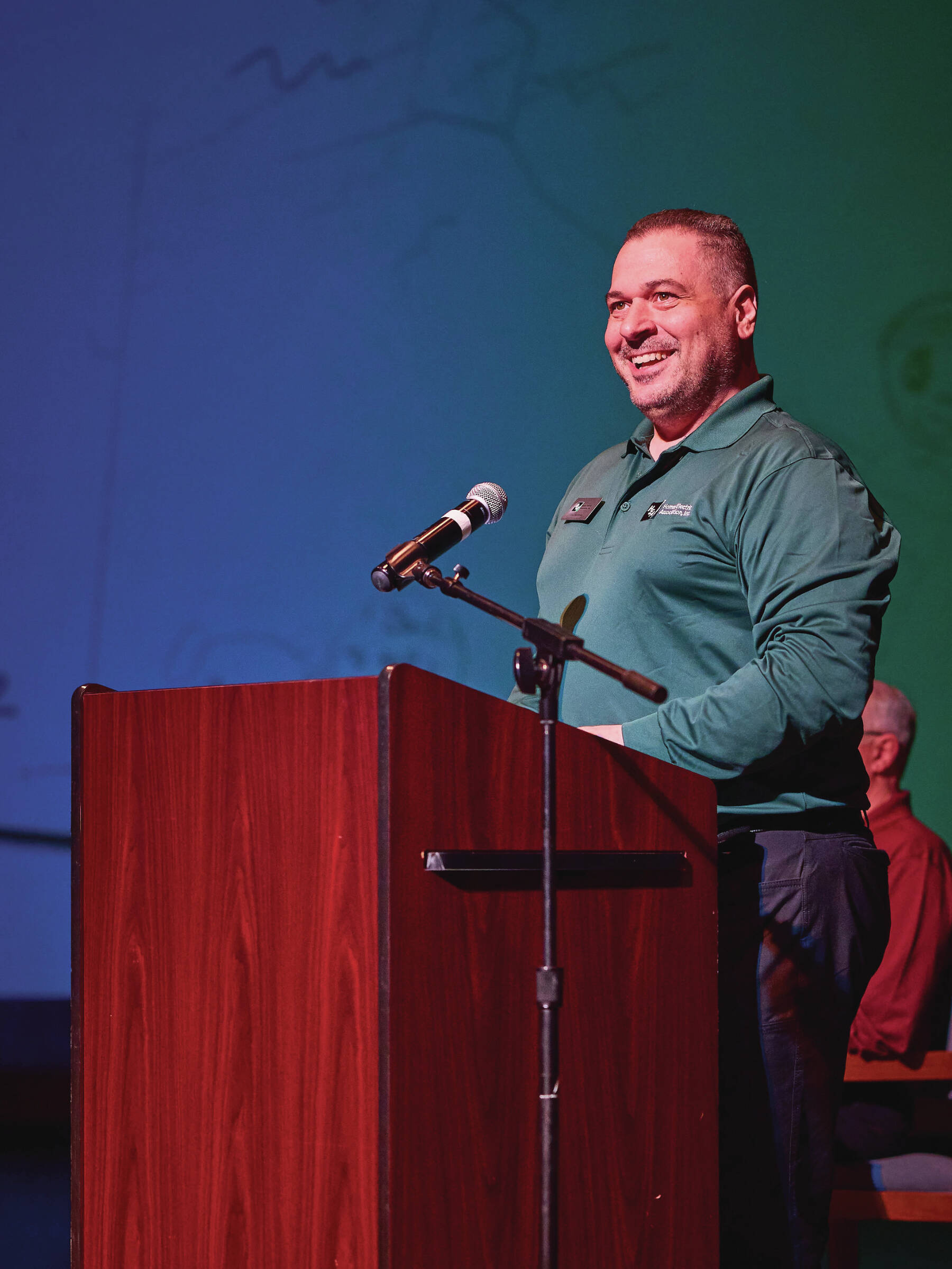 Joe Halstead from HEA's information technology team addresses attendees at the annual public meeting in the Homer High School Theatre on May 2, 2024.  Photo provided by Christopher Kincaid.