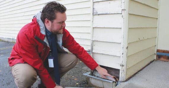 Soldotna Elementary School Principal Dr. Austin Stevenson points out corroded insulation outside of the school building on Friday, Sept. 30, 2022 in Soldotna, Alaska. (Ashlyn O’Hara/Peninsula Clarion)