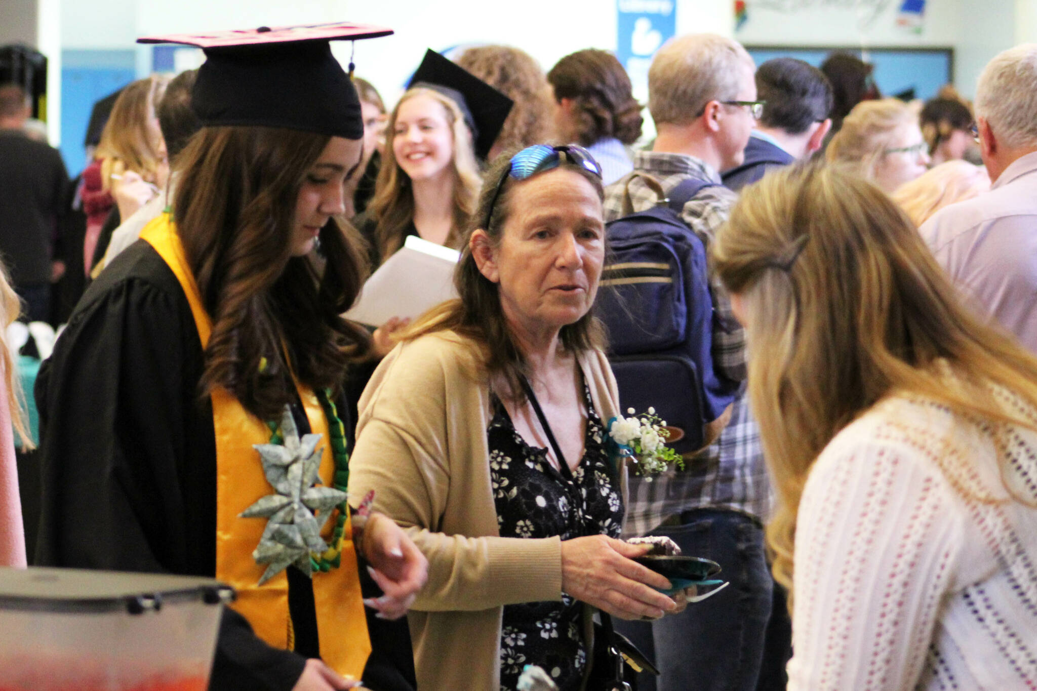 Kenai Peninsula Borough School District school board member Dianne MacRae (center) joins graduates for cake after Connections Homeschool’s 2024 commencement ceremony on Thursday, May 16, 2024 in Soldotna, Alaska. (Ashlyn O’Hara/Peninsula Clarion)