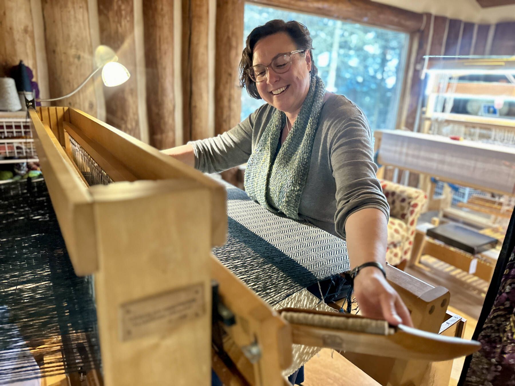 Fiber artist Lisa Talbott weaves a blanket at her Tools of the Trade jack loom on Tuesday, June 11, 2024, in the Kindred Spirits Weaving Studio she shares with Bonita Banks in Homer, Alaska. Photo by Christina Whiting