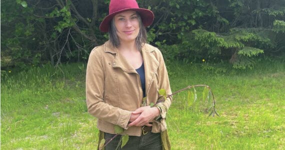 Carla Klinker poses with a long nettle stalk at the Homer News office on Saturday, June 22, 2024 in Homer, Alaska. (Emilie Springer/Homer News)