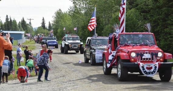 Participants in the Anchor Point Fourth of July parade toss candy out to kids and spectators on Thursday. (Delcenia Cosman/Homer News)