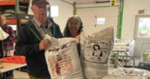 Al and Grace Poindexter pose with the Fishy Peat potting soil in the Anchor Point Greenhouse on July 8, 2024, in Anchor Point, Alaska. (Emilie Springer/ Homer News)