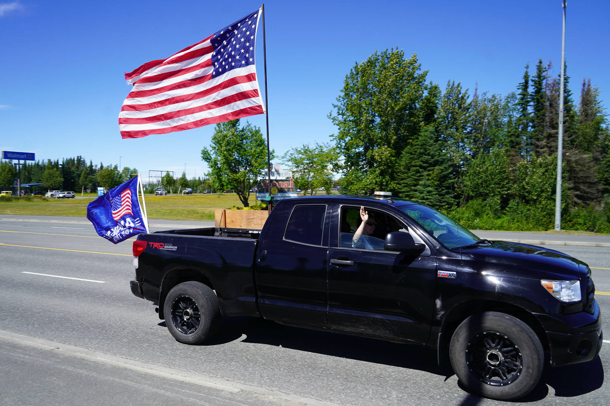 A parade of cars and trucks flying flags in support of former President Donald Trump proceed down the Kenai Spur Highway in Kenai, Alaska, on Sunday, July 14, 2024. (Jake Dye/Peninsula Clarion)