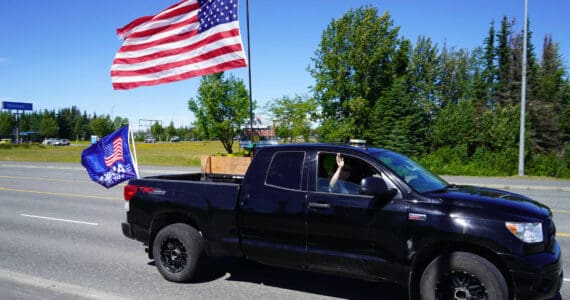 A parade of cars and trucks flying flags in support of former President Donald Trump proceed down the Kenai Spur Highway in Kenai, Alaska, on Sunday, July 14, 2024. (Jake Dye/Peninsula Clarion)