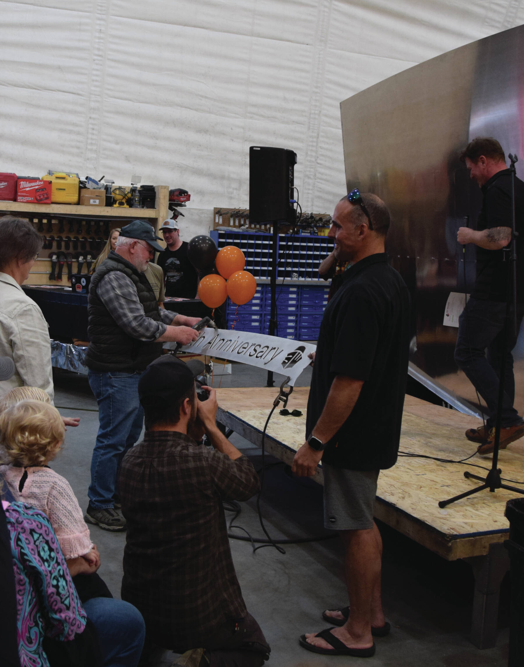 Founder Allen Engebretsen prepares to cut the aluminum 50th anniversary ribbon last Friday at the Bay Weld boat shop.  Emilie Springer/ Homer News