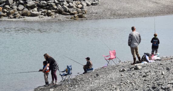 Parents show their kids how to cast their fishing lines during the youth-only coho salmon fishery on Saturday, Aug. 5, 2023 at the Nick Dudiak Fishing Lagoon on the Homer Spit in Homer, Alaska. (Delcenia Cosman/Homer News)