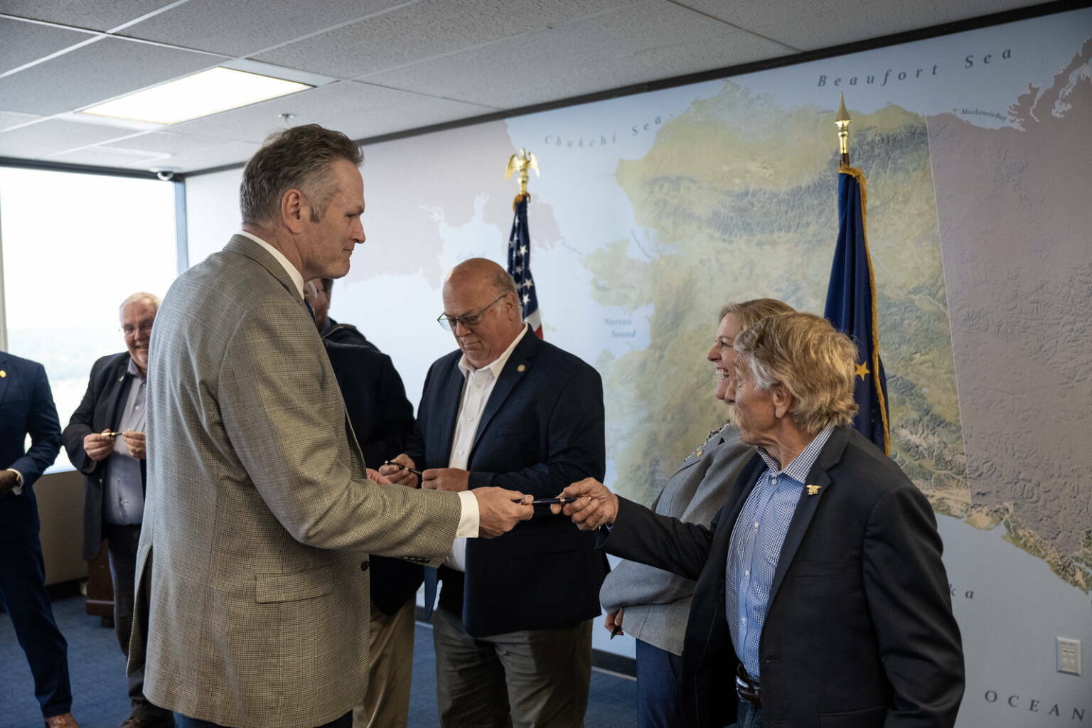 Gov. Mike Dunleavy hands out pens he used to sign the budget bills for the fiscal year that began July 1 to state lawmakers during a private ceremony in Anchorage on Thursday, June 27, 2024. (Official photo from The Office of the Governor)