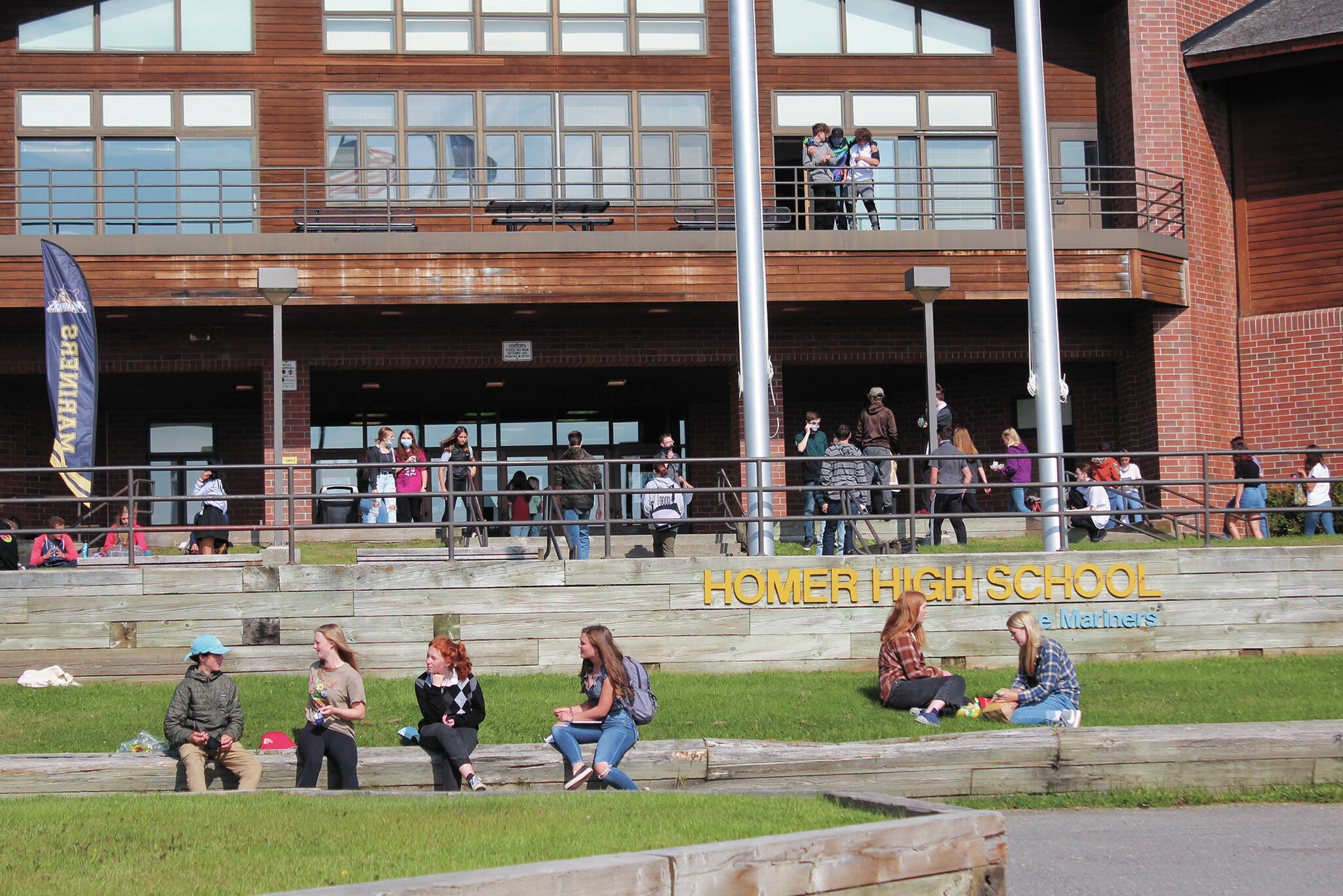 Homer High School students finish eating lunch outside the school while others make their way back into the building for the next class period on Monday, Aug. 24, 2020, in Homer, Alaska. (Photo by Megan Pacer/Homer News)