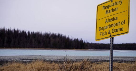 An Alaska Department of Fish and Game regulatory marker is seen at the outlet of Skilak Lake near Cooper Landing, Alaska, on Saturday, March 23, 2024. (Jake Dye/Peninsula Clarion)