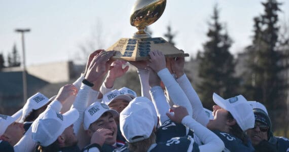 Soldotna hoists the First National Bowl on Saturday, Oct. 21, 2023, after the Division II championship game at Service High School in Anchorage, Alaska. (Photo by Jeff Helminiak/Peninsula Clarion)