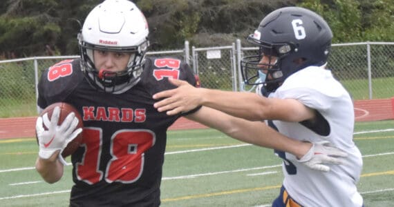 Kenai Central’s Aasen Campanella rushes the ball against Homer’s Austin Briscoe on Saturday, Aug. 17, 2024, at Ed Hollier Field at Kenai Central High School in Kenai, Alaska. (Photo by Jeff Helminiak/Peninsula Clarion)