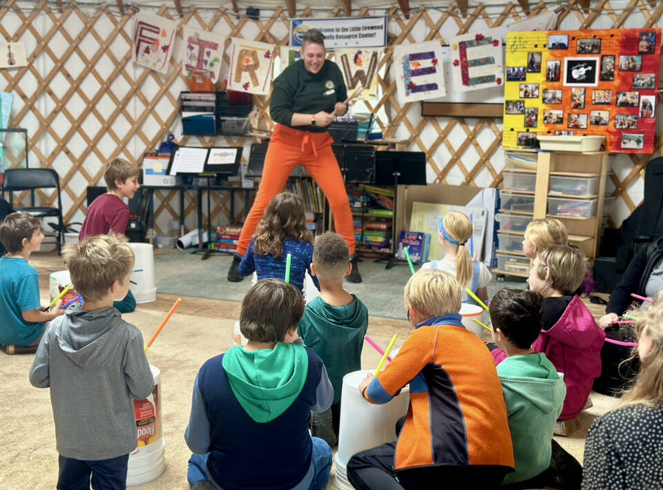 New and returning Homer OPUS students participate in a session of bucket drumming with Gretchen Grube, a visiting violinist, violin instructor and member of the Chicago-based band, The Gleasons, during a fall semester kickoff party at Little Fireweed Academy on Sunday, Aug. 18, 2024, in Homer, Alaska. Photo by Christina Whiting