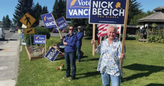 Homer residents hold political signs in support of Alaska House District 6 candidates at WKFL park in Homer on Aug. 20, 2024, in Homer, Alaska. (Emilie Springer/ Homer News)