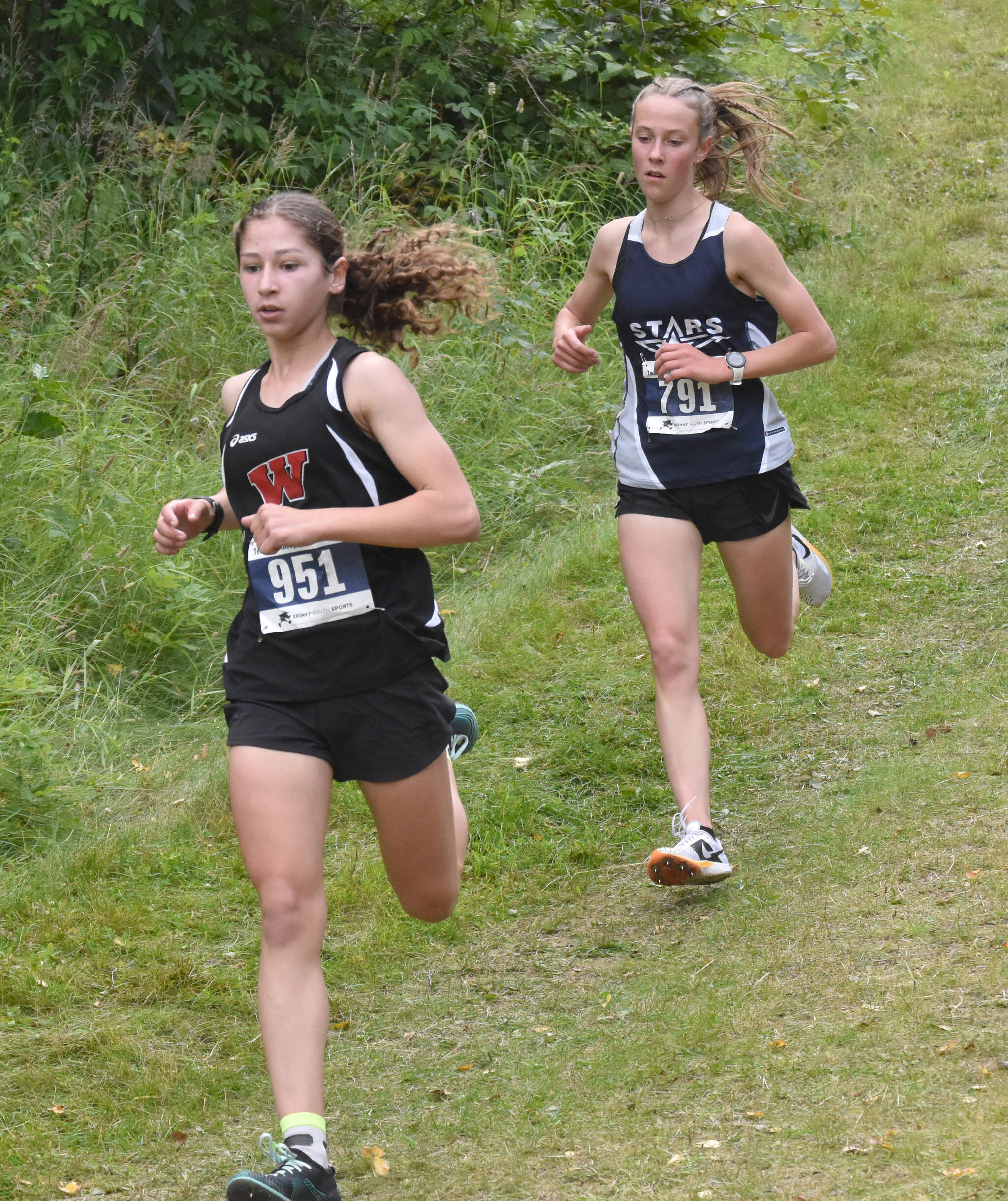 Wasilla’s Hailee Giacobbe leads Soldotna’s Tania Boonstra at the Ted McKenney XC Invitational on Saturday, Aug. 24, 2024, at Tsalteshi Trails just outside of Soldotna, Alaska. (Photo by Jeff Helminiak/Peninsula Clarion)