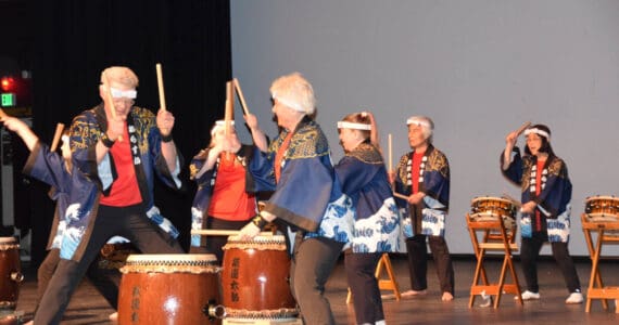 Frank Jeffries (front left) and Jacki Holzman (front right) play together during Tomodachi Daiko’s first taiko drum performance on Saturday, May 4, 2024 in the Homer High School Mariner Theatre in Homer, Alaska. Pictured in the background are Naoyuki Furuta (left), one of the leaders of Tokyo-based taiko group Chokoma, and TDI founder Sachiko Kono (right). (Delcenia Cosman/Homer News)