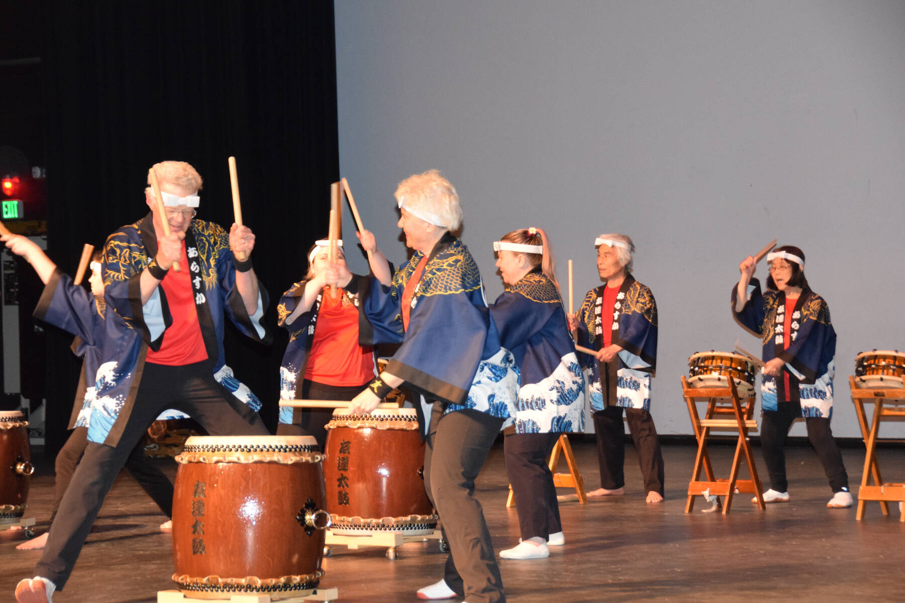 Frank Jeffries (front left) and Jacki Holzman (front right) play together during Tomodachi Daiko’s first taiko drum performance on Saturday, May 4, 2024 in the Homer High School Mariner Theatre in Homer, Alaska. Pictured in the background are Naoyuki Furuta (left), one of the leaders of Tokyo-based taiko group Chokoma, and TDI founder Sachiko Kono (right). (Delcenia Cosman/Homer News)