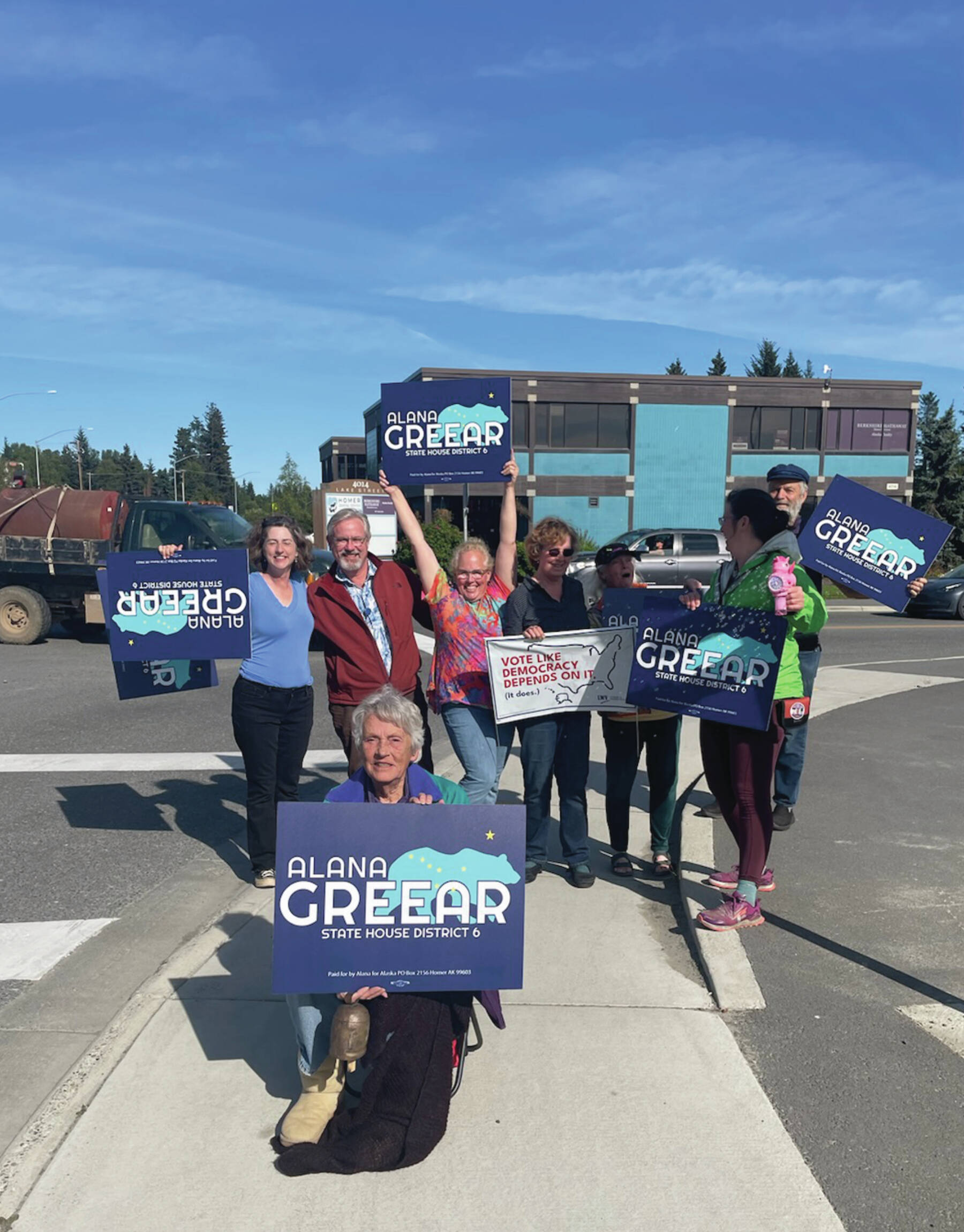 Alaska House District 6 candidate Alana Greear (back, center) poses with supporters at the corner of Pioneer Avenue and Lake Street in Homer during the primary election on Aug. 20, 2024. ( Emilie Springer/Homer New)