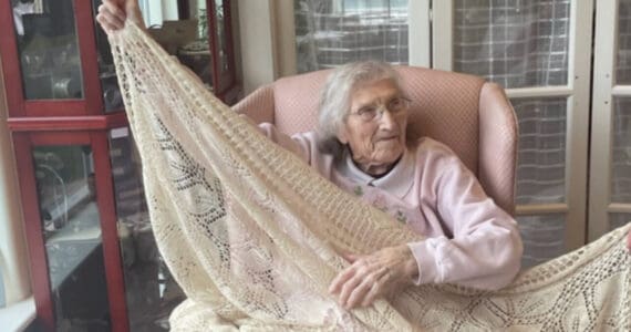 Dorris James, who will turn 100 on Sept. 28, 2024, displays a crocheted tablecloth that she made several decades ago. The photo was taken on Sept. 11, 2024, at her daughter’s home in Homer, Alaska. (Emilie Springer/ Homer News)