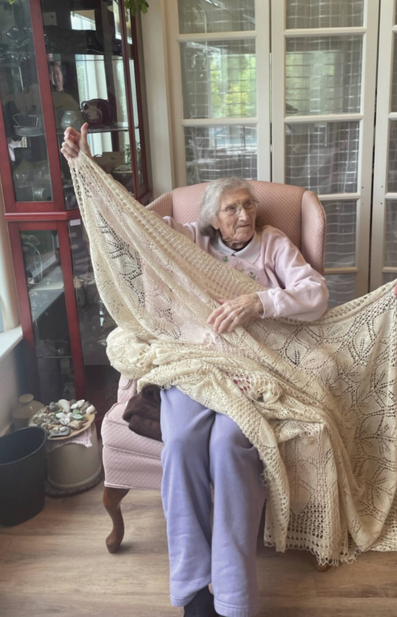 Dorris James, about to turn 100 years old, displays a crocheted tablecloth that she made several decades ago. The photo was taken on Sept. 11 at her daughter’s home in Homer. (Emilie Springer/ Homer News)