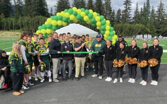 Center, from left: Kenai Peninsula Borough School District Superintendent Clayton Holland; Borough Mayor Peter Micciche; Seward High Student Council President Otto Nipp; and Seward High School Principal Dr. Henry Burns participate in a ribbon-cutting ceremony for a new turf field at Roger Steinbrecher Memorial Field at Seward High School, Friday, Sept. 13, 2024, in Seward, Alaska. (Photo by Jeff Helminiak/Peninsula Clarion)