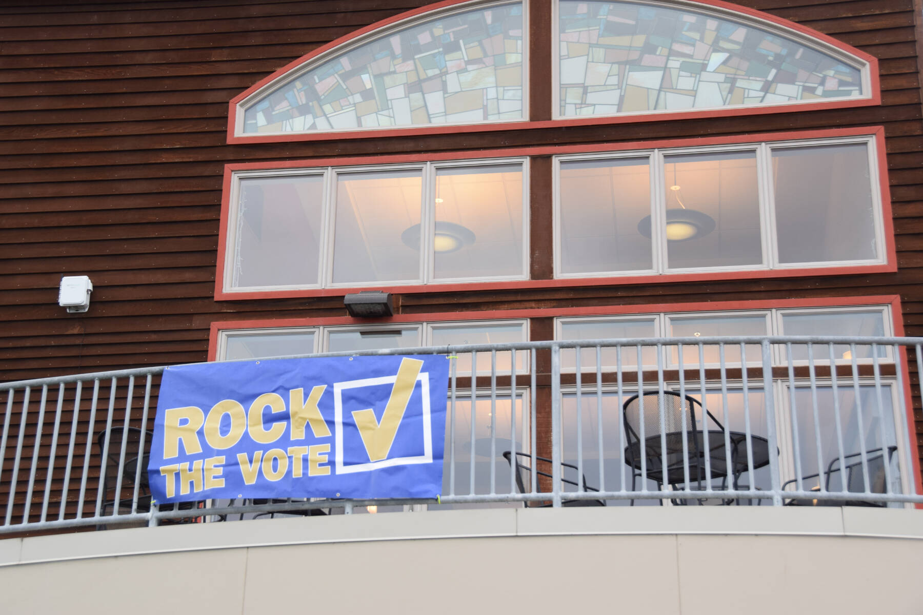 A “Rock the Vote” sign is displayed on the second-floor balcony outside Kachemak Bay Campus’s Pioneer Hall on Tuesday, Sept. 17, 2024, in Homer, Alaska. (Delcenia Cosman/Homer News)