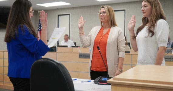 Administrative Secretary Nikkol Sipes administers oaths of office to Kenai Peninsula Borough School District Board of Education members Kelley Cizek and Sarah Douthit on Monday, Oct. 14, 2024. Cizek was reelected to represent Sterling and Funny River, Douthit was elected to represent Kenai during the Oct. 1 municipal election. (Jake Dye/Peninsula Clarion)