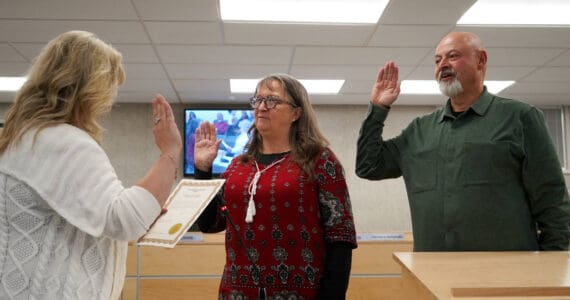 Borough Clerk Michele Turner administers oaths of office to Cindy Ecklund and James Baisden during a meeting of the Kenai Peninsula Borough Assembly in Soldotna, Alaska, on Tuesday, Oct. 8, 2024. Ecklund was reelected and Baisden was elected to the assembly during the Oct. 1 election. (Jake Dye/Peninsula Clarion)