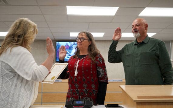 Borough Clerk Michele Turner administers oaths of office to Cindy Ecklund and James Baisden during a meeting of the Kenai Peninsula Borough Assembly in Soldotna, Alaska, on Tuesday, Oct. 8, 2024. Ecklund was reelected and Baisden was elected to the assembly during the Oct. 1 election. (Jake Dye/Peninsula Clarion)