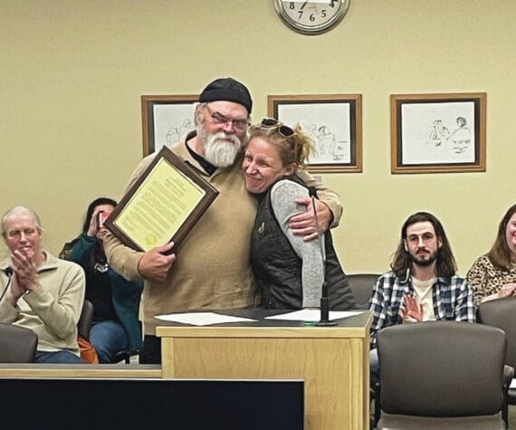 Homer’s new mayor, Rachel Lord, presents outgoing Mayor Ken Castner with a plaque recognizing his service to the City of Homer at the conclusion of the city council meeting at the Cowles Council Chambers at Homer City Hall on Oct. 14, 2024, in Homer, Alaska. (Emilie Springer/Homer News)