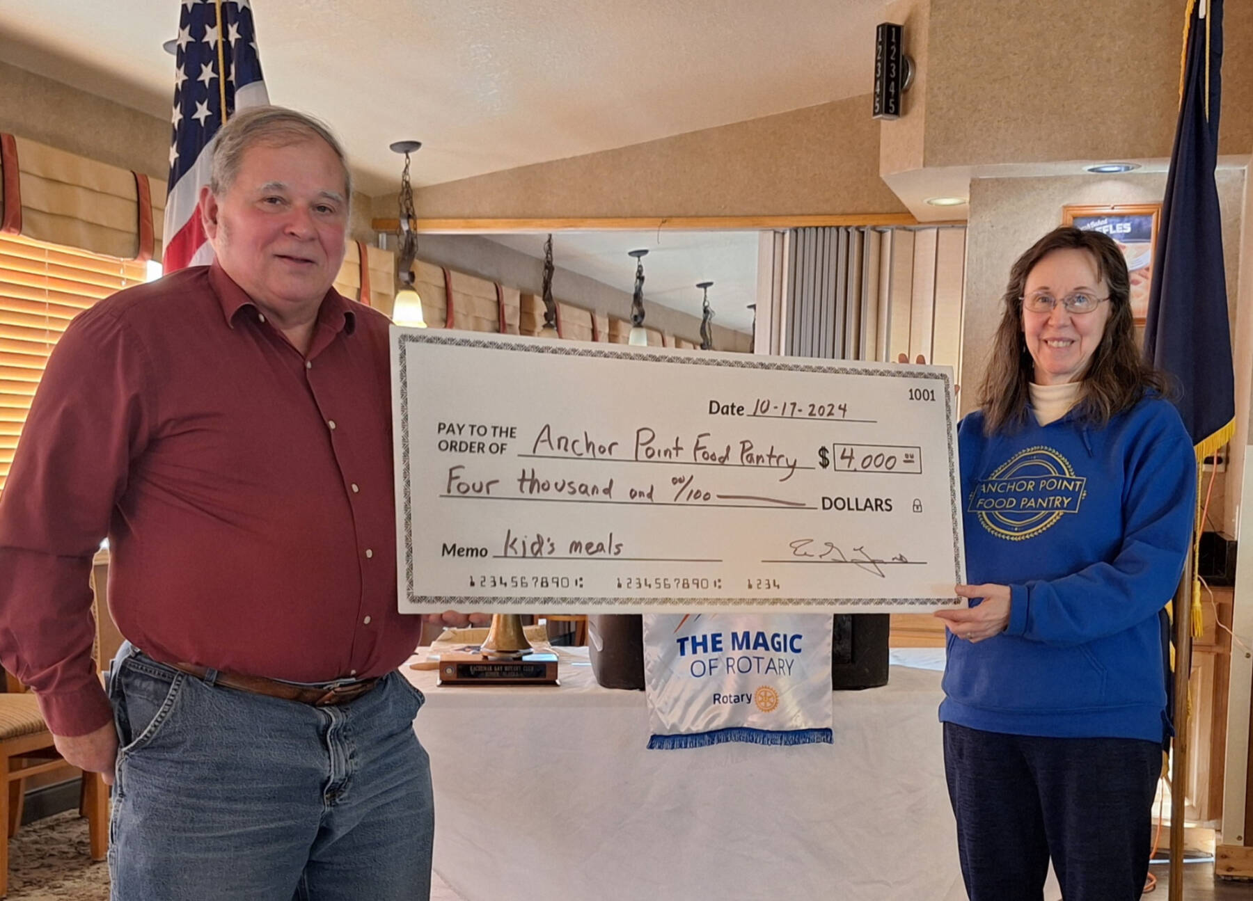 Eric Young (right), president of the Rotary Club of Homer-Kachemak Bay presents a check to Anchor Point Food Pantry President Missy Martin (right) on Thursday, Oct. 17, 2024, to fund meals for area youth. Photo provided by Kim Zook