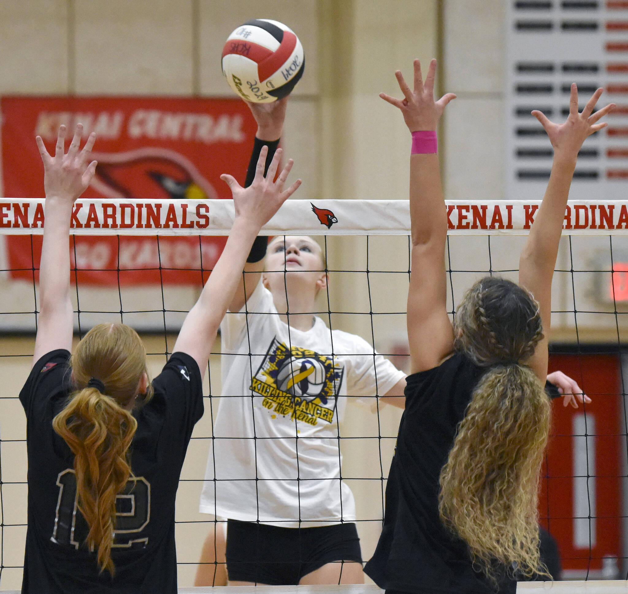 Soldotna's Cassidy Kruse attacks against Kenai Central's Ellsi Miller and Sophie Tapley on Friday, Nov. 1, 2024, at Kenai Central High School in Kenai, Alaska. (Photo by Jeff Helminiak/Peninsula Clarion)