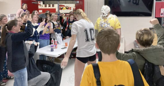 Soldotna's Cassidy Kruse hits Soldotna head coach Luke Baumer with a pie as part of the Killing Cancer on the Kenai event on Friday, Nov. 1, 2024, at Kenai Central High School in Kenai, Alaska. (Photo by Jeff Helminiak/Peninsula Clarion)