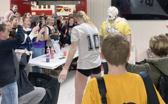 Soldotna's Cassidy Kruse hits Soldotna head coach Luke Baumer with a pie as part of the Killing Cancer on the Kenai event on Friday, Nov. 1, 2024, at Kenai Central High School in Kenai, Alaska. (Photo by Jeff Helminiak/Peninsula Clarion)