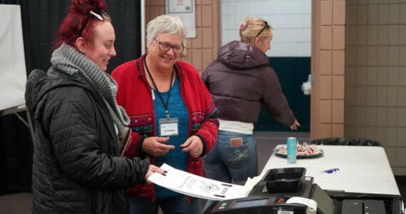 Poll worker Carol Louthan helps voters submit ballots at the Soldotna Regional Sports Complex in Soldotna, Alaska, on Tuesday, Nov. 5, 2024. (Jake Dye/Peninsula Clarion)