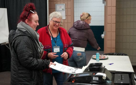 Poll worker Carol Louthan helps voters submit ballots at the Soldotna Regional Sports Complex in Soldotna, Alaska, on Tuesday, Nov. 5, 2024. (Jake Dye/Peninsula Clarion)