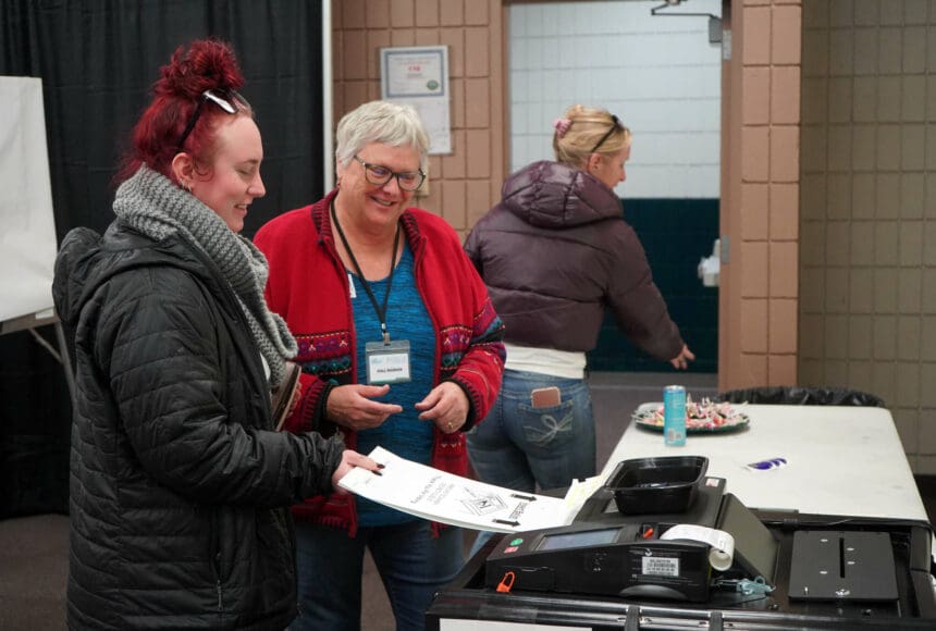 <p>Poll worker Carol Louthan helps voters submit ballots at the Soldotna Regional Sports Complex in Soldotna, Alaska, on Tuesday, Nov. 5, 2024. (Jake Dye/Peninsula Clarion)</p>