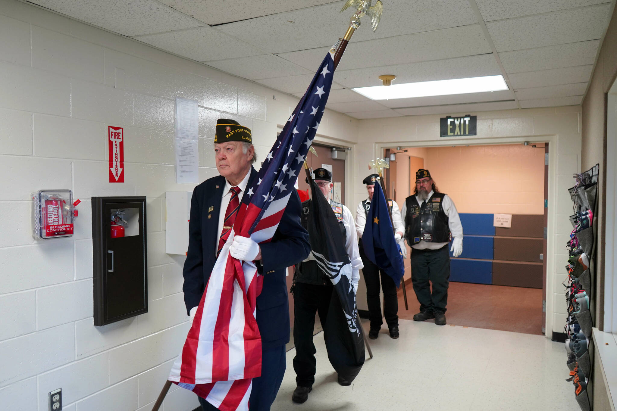 The American Legion Post 20’s color guard proceeds into the Mountain View Elementary gym in Kenai, Alaska, during a celebration of Veterans Day on Monday, Nov. 11, 2024. (Jake Dye/Peninsula Clarion)