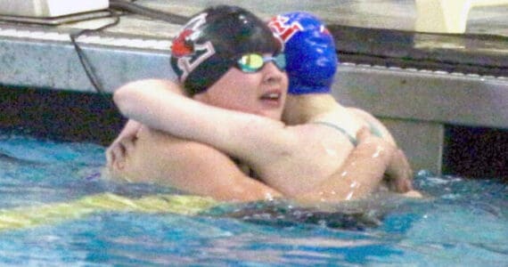 Kenai’s Abigail Price hugs Taryn Fleming from Sitka during the state swimming and diving championships Saturday, Nov. 9, 2024, at Bartlett High School in Anchorage, Alaska. (Photo by Kyle Wilkinson/For the Frontiersman)