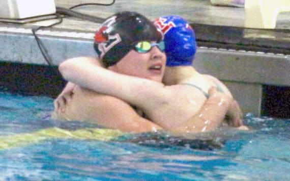 Kenai’s Abigail Price hugs Taryn Fleming from Sitka during the state swimming and diving championships Saturday, Nov. 9, 2024, at Bartlett High School in Anchorage, Alaska. (Photo by Kyle Wilkinson/For the Frontiersman)