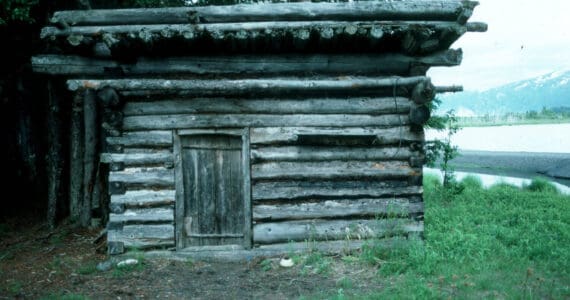 The log shed at Blake’s Place on the north shore on Tustumena Lake, near the outlet of Indian Creek. Kerri Dolph holed up here for several days after the death of her husband John. (Photo by Clark Fair, 1985)