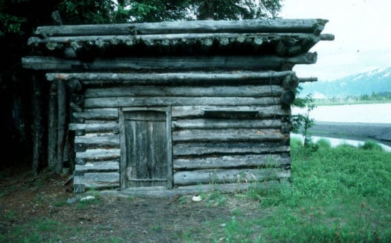 The log shed at Blake’s Place on the north shore on Tustumena Lake, near the outlet of Indian Creek. Kerri Dolph holed up here for several days after the death of her husband John. (Photo by Clark Fair, 1985)