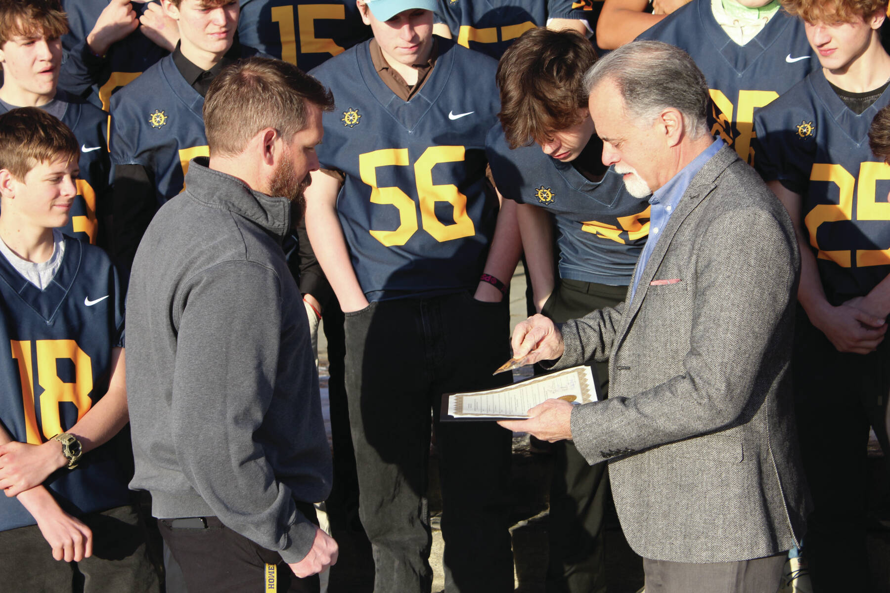 Photo by Leland Curtis
Kenai Peninsula Borough Mayor Peter Micciche presents an award for the varsity Mariners winning the 2024 state championship game to Homer High School Athletic Director and head football coach Justin Zank on Thursday, Nov. 21 at Homer High School.