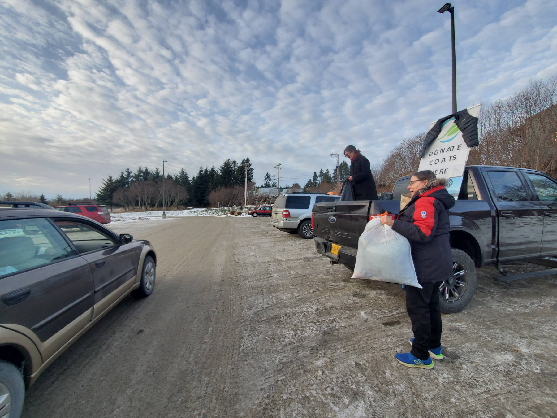 Katie Rich and Joanna Tornes (right) hold a coat drive for Port Graham and Nanwalek in the Homer Public Library parking lot on Saturday, Nov. 23, 2024, in Homer, Alaska. (Delcenia Cosman/Homer News)