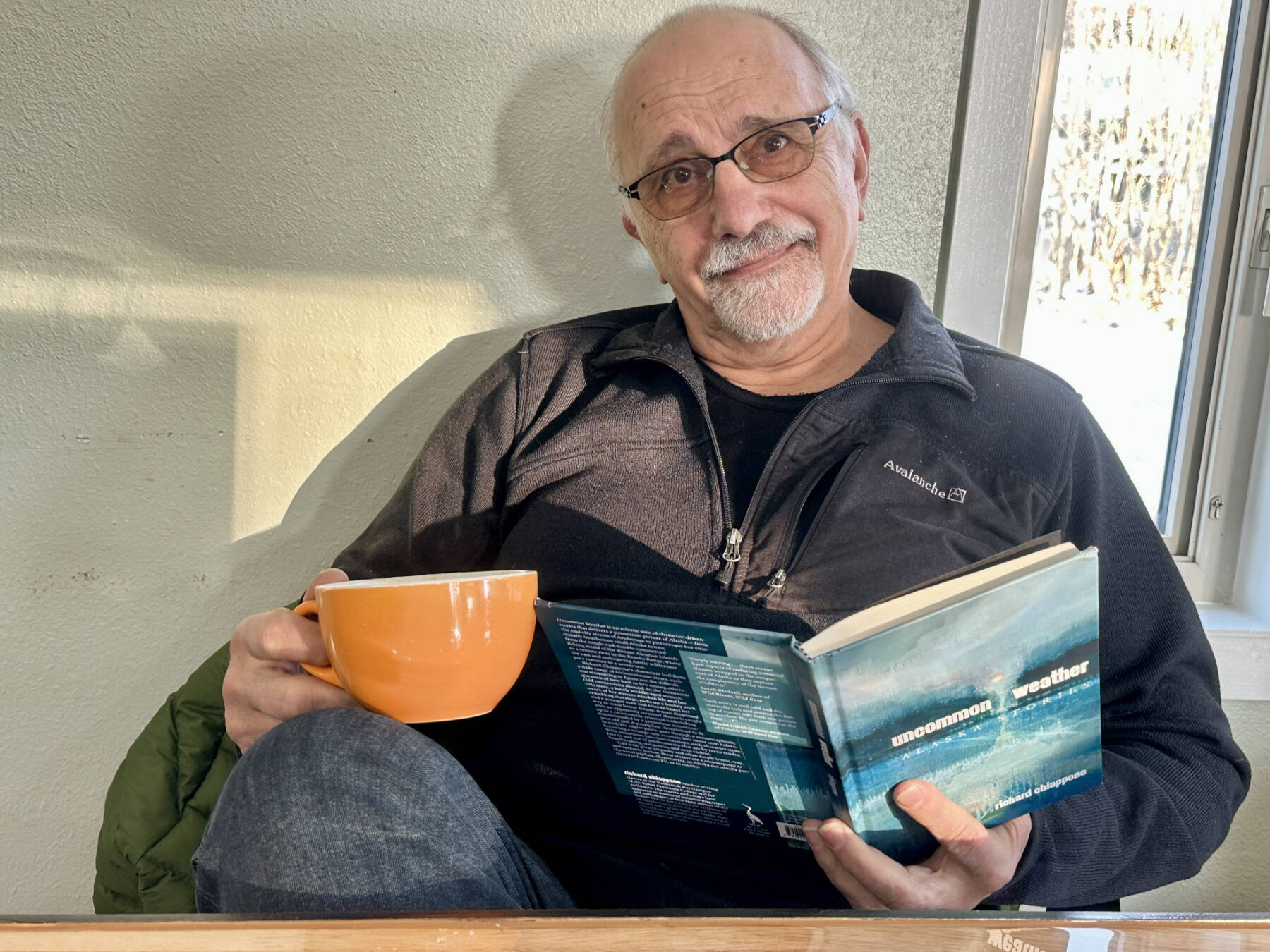 Homer author Rich Chiappone visits ZenDen Cafe with his newest book of short stories, “Uncommon Weather,” on Friday, Nov. 22, 2024, in Homer, Alaska. Photo by Christina Whiting