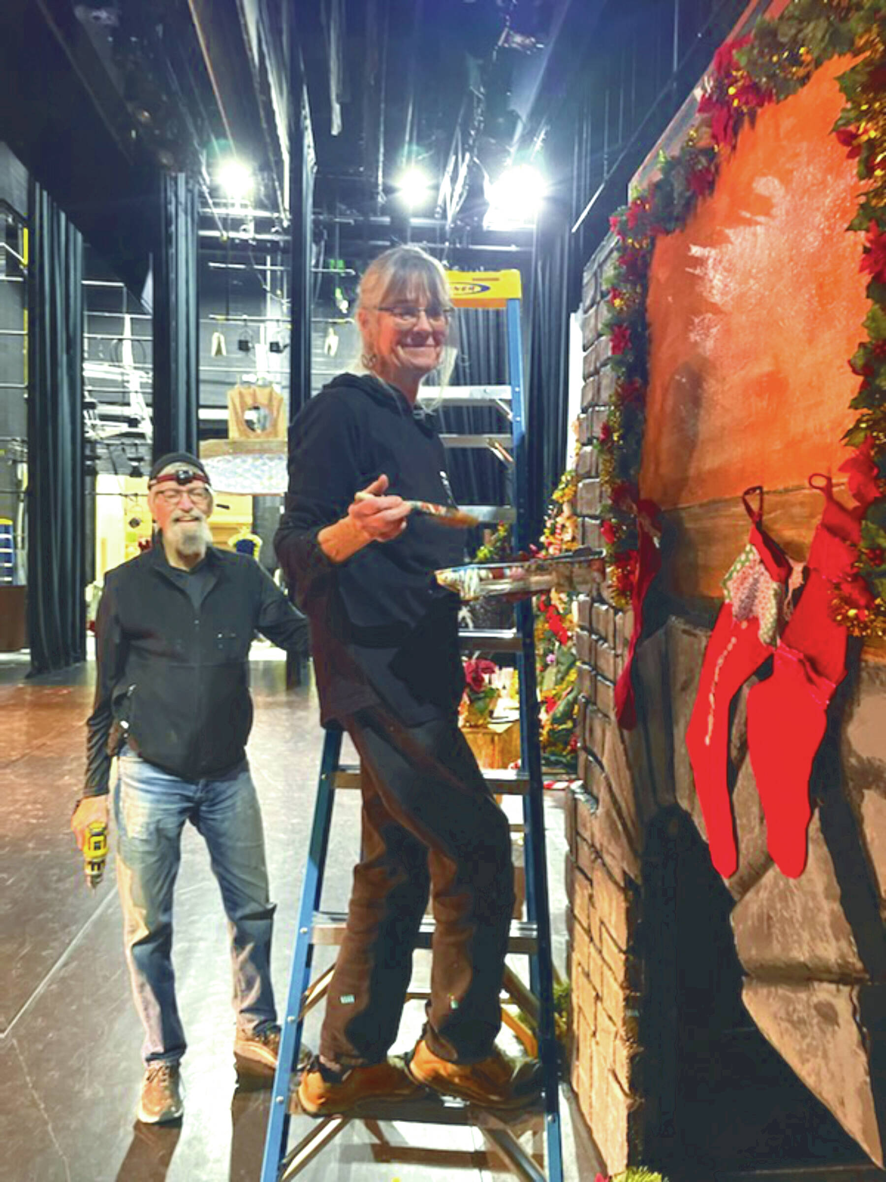 Michael McKinney and Bobby McKinney add finishing touches to the party scene fireplace at the Homer “Nutcracker” rehearsals on Sunday Dec. 1, 2024, at the Homer Mariner Theater, in Homer, Alaska. (Emilie Springer/ Homer News)