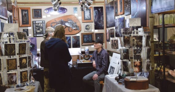 Artist Jeff Dean (right) talks to patrons at his booth at the annual Nutcracker Faire sponsored by Homer Council on the Arts on Saturday, Dec. 2, 2023 at Homer High School in Homer, Alaska. (Delcenia Cosman/Homer News)