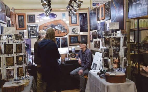 Artist Jeff Dean (right) talks to patrons at his booth at the annual Nutcracker Faire sponsored by Homer Council on the Arts on Saturday, Dec. 2, 2023 at Homer High School in Homer, Alaska. (Delcenia Cosman/Homer News)