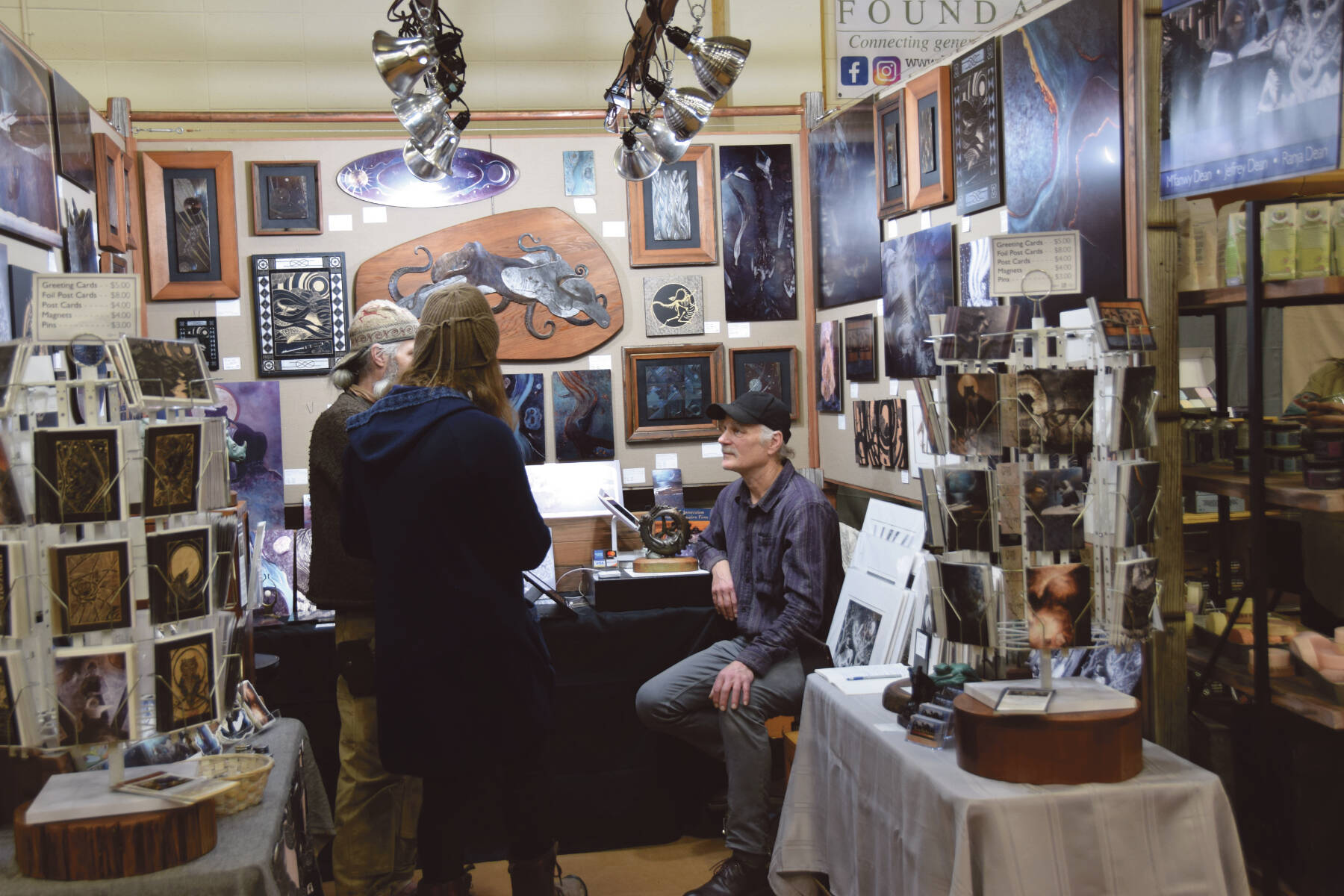 Artist Jeff Dean (right) talks to patrons at his booth at the annual Nutcracker Faire sponsored by Homer Council on the Arts on Saturday, Dec. 2, 2023 at Homer High School in Homer, Alaska. (Delcenia Cosman/Homer News)